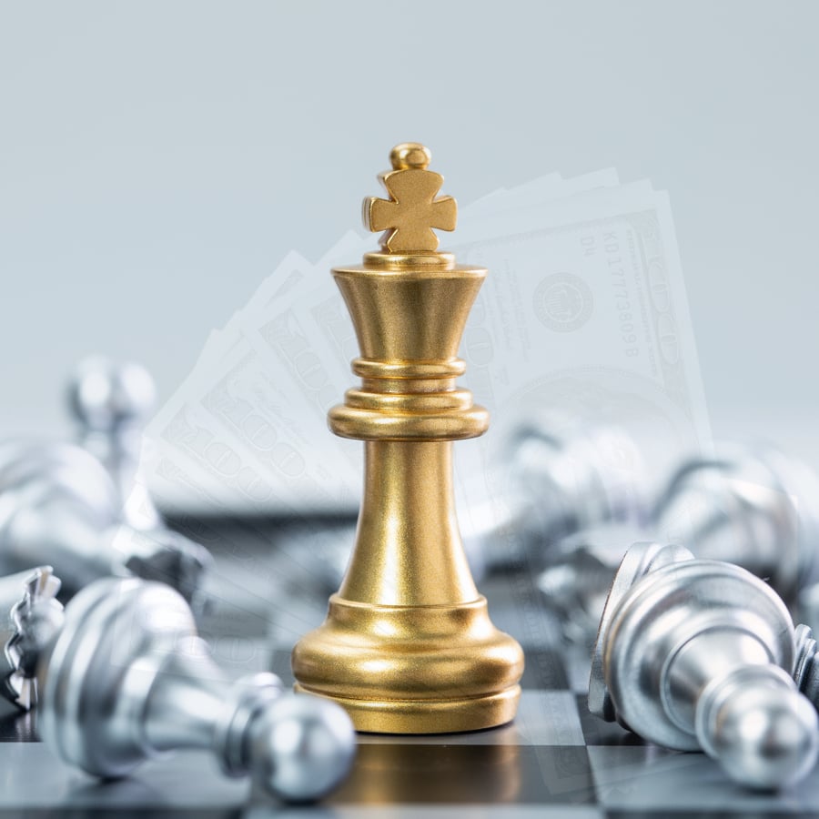Golden chess king surrounded by silver pawns on a chessboard, symbolizing cash as strategic power in investing and negotiation.